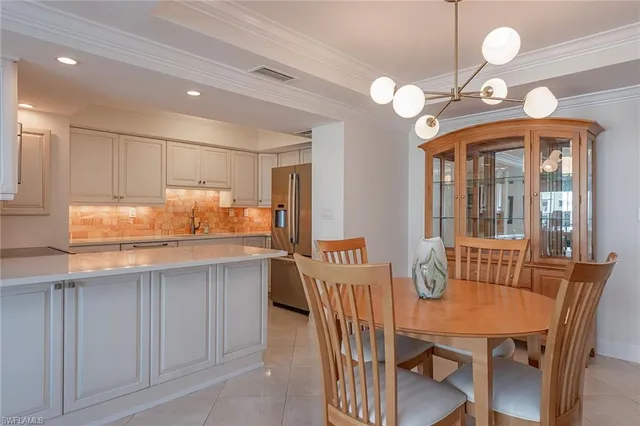 a kitchen with granite countertop a table chairs in it and wooden floors