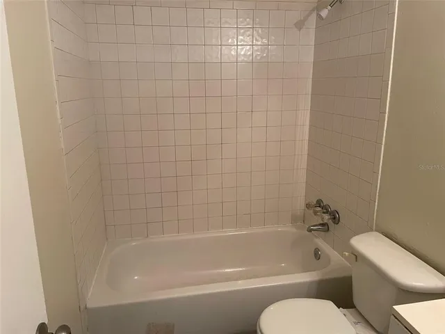 a white bath tub sitting next to a white toilet and sink