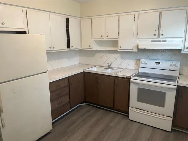 a kitchen with stainless steel appliances a stove and white cabinets