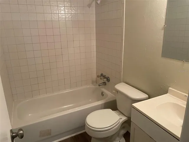 a white toilet and tub sitting next to a bathroom sink