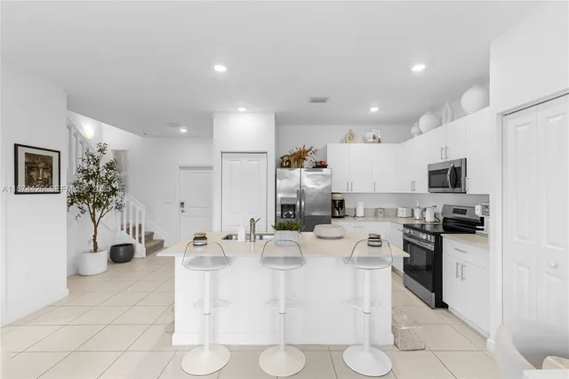 a kitchen with stainless steel appliances kitchen island granite countertop a sink and cabinets