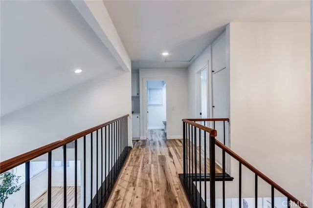 a view of a hallway with wooden floor and staircase