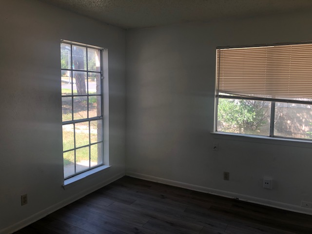 404 West Dittmar Road Austin, TX 78745 - Photo 11 of 15 Unfurnished room with plenty of natural light, dark wood-type flooring, and a textured ceiling