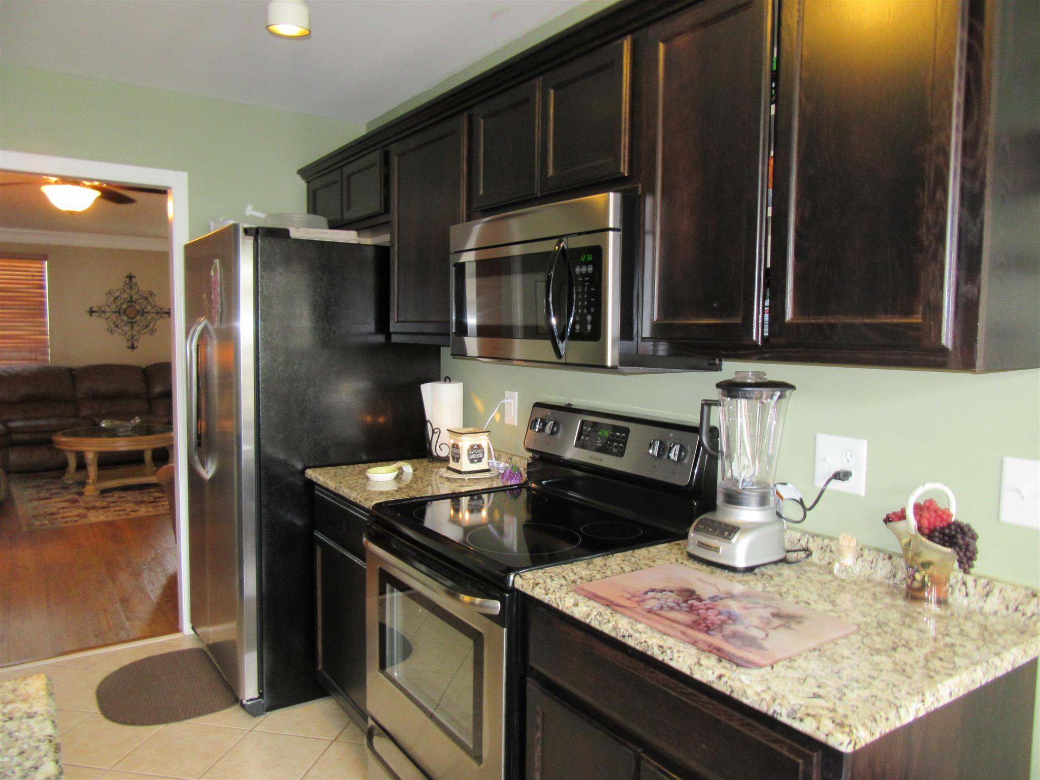 1252 General George Patton Road Nashville, TN 37221 - Photo 6 of 30 a kitchen with granite countertop stainless steel appliances and wooden cabinets