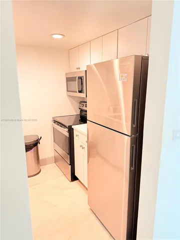 a hallway with a view of kitchen with wooden floor