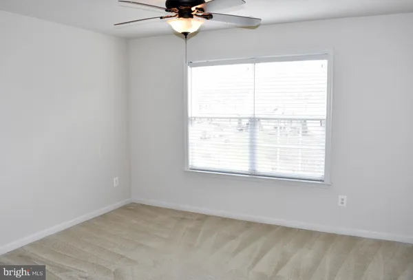 a view of a livingroom with a ceiling fan and window