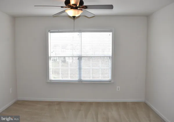 a view of an empty room with a window and fireplace