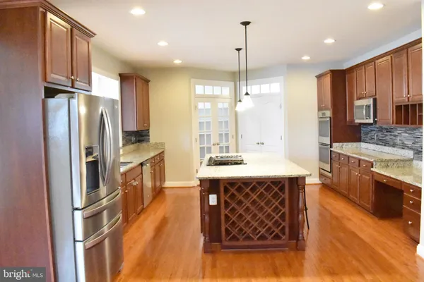 a kitchen with a wooden floor and a large window