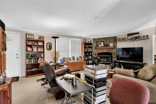 a living room with furniture a flat screen tv and a fireplace