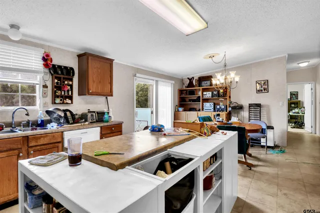 a open dining room with stainless steel appliances a table and chairs with wooden floor