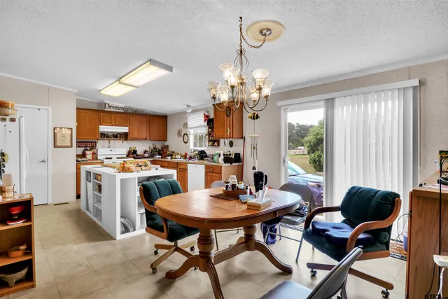 a view of a dining room with furniture and a chandelier
