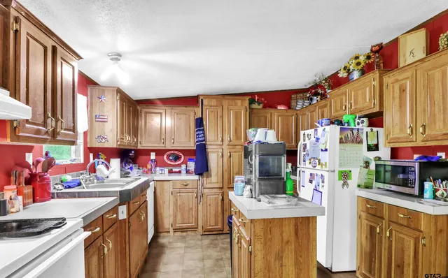 a kitchen that has a lot of white cabinets and stainless steel appliances