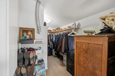a view of walk in closet with clothes and shoes