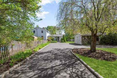 a view of a house with a yard and pathway