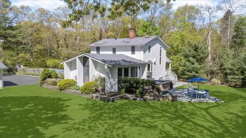 a aerial view of a house with a yard table and chairs