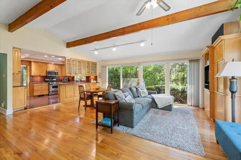 a living room with fireplace furniture and a large window