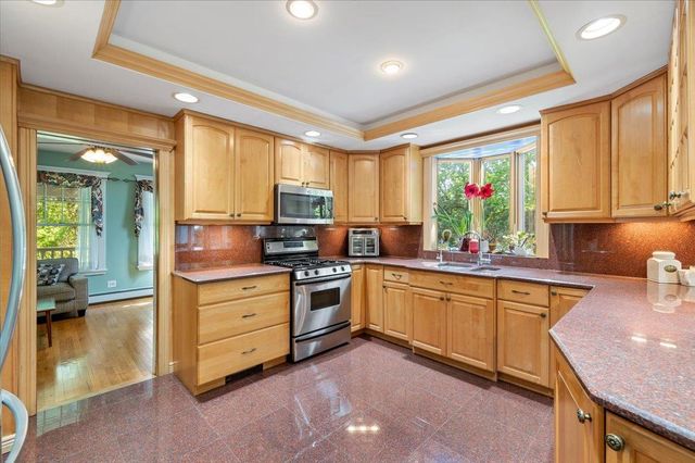 a kitchen with stainless steel appliances granite countertop a sink stove and refrigerator