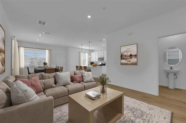 a living room with furniture and a wooden floor