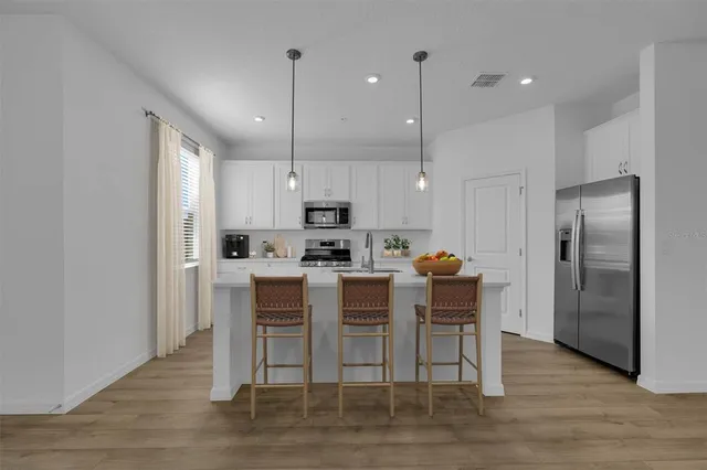 a kitchen with kitchen island wooden cabinets and stainless steel appliances