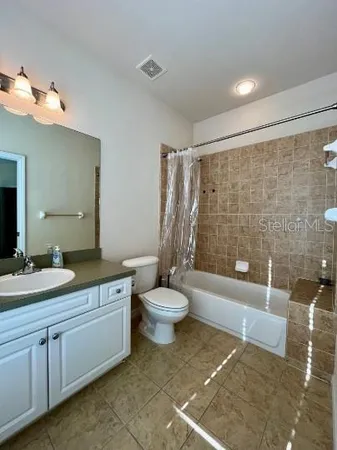 a bathroom with a granite countertop sink toilet a mirror and a bathtub