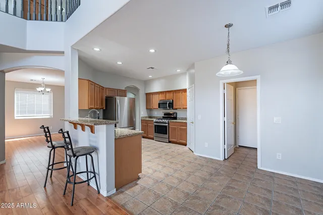 a kitchen with stainless steel appliances granite countertop a refrigerator and a stove top oven