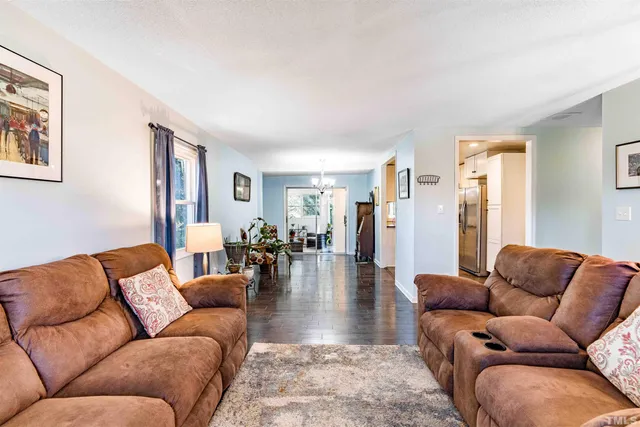 a living room with furniture wooden floor and a large window