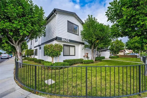 a front view of a house with a garden and plants