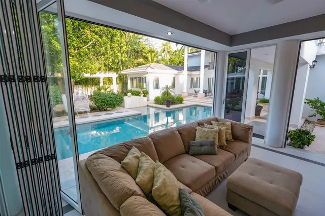 a living room with patio furniture and a chandelier