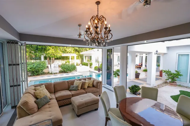 a dining room with furniture a chandelier and window