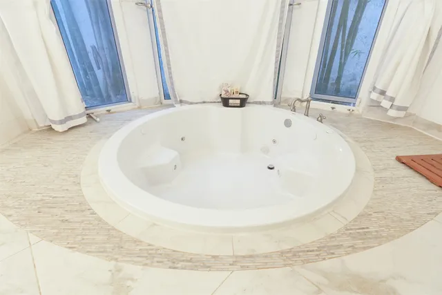 a bathroom with a tub sink and mirror