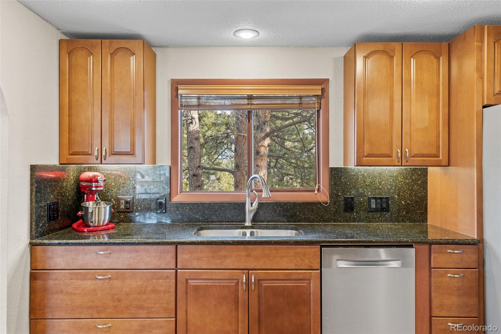1995 Mockingbird Trail Bailey, CO 80421 - Photo 11 of 24 a kitchen with granite countertop a sink window and cabinets