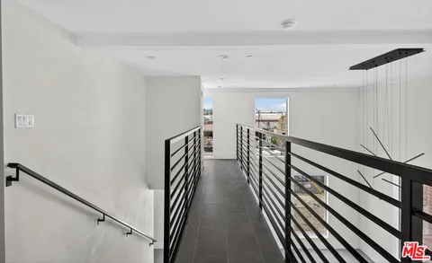 a view of a hallway with wooden floor and stairs