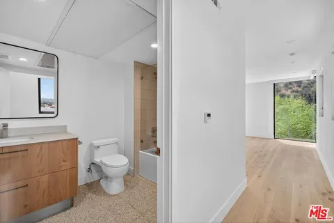 a spacious bathroom with a toilet a sink and a large mirror
