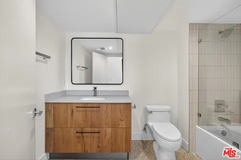 a bathroom with a toilet a sink and mirror