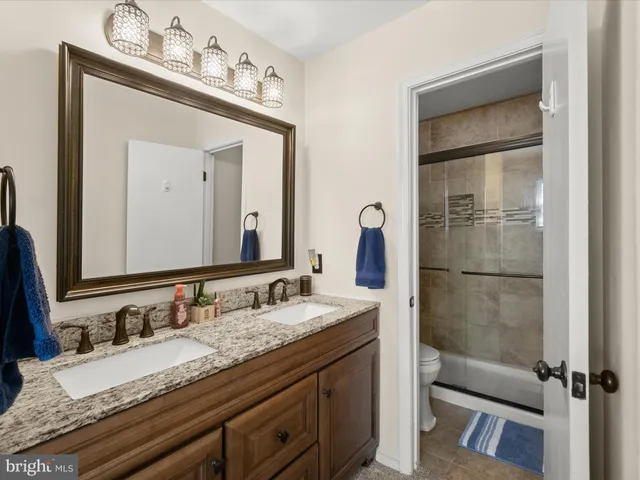 a bathroom with a granite countertop sink vanity and mirror