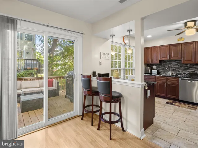 a kitchen with stainless steel appliances kitchen island granite countertop a stove a refrigerator a sink with a dining table and chairs