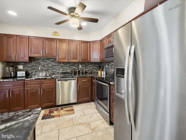 a kitchen with stainless steel appliances granite countertop a refrigerator sink and cabinets