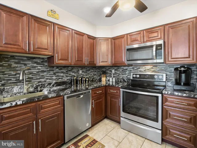 a kitchen with stainless steel appliances granite countertop a stove microwave and cabinets