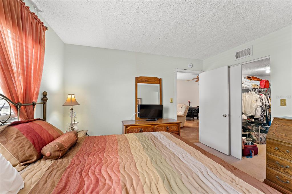 4746 Azalea Drive, Unit 105C New Port Richey, FL 34652 - Photo 11 of 27 a bedroom with a bed and wooden floor