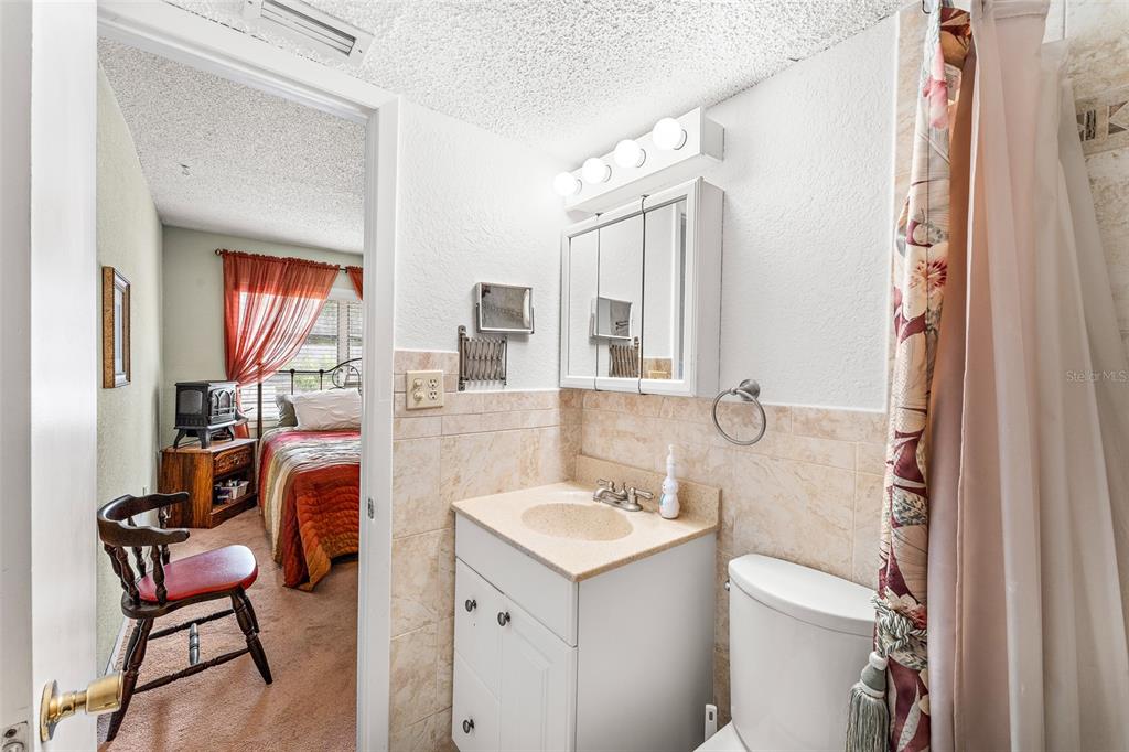 4746 Azalea Drive, Unit 105C New Port Richey, FL 34652 - Photo 14 of 27 a bathroom with a sink toilet and a mirror