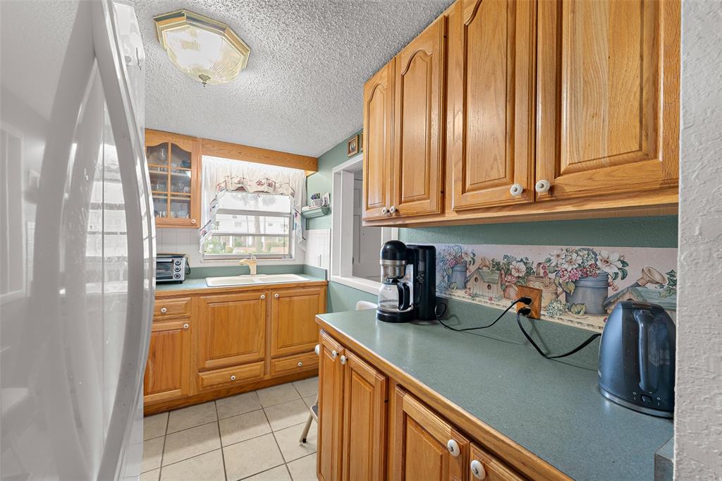 4746 Azalea Drive, Unit 105C New Port Richey, FL 34652 - Photo 8 of 27 a kitchen with stainless steel appliances granite countertop a refrigerator and a sink