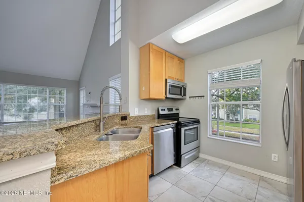 a kitchen with stainless steel appliances granite countertop a sink stove and microwave