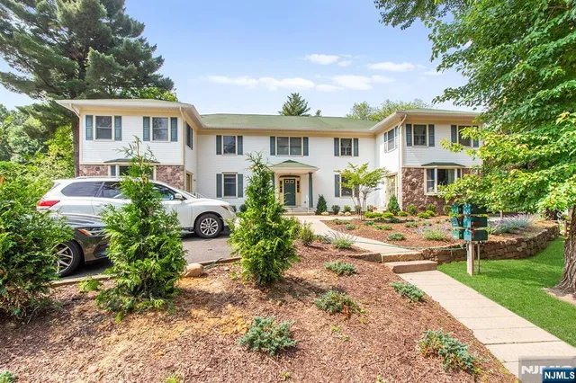a front view of a house with garden and porch