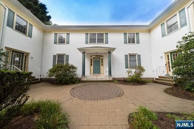 a view of a house with brick walls and a yard with plants