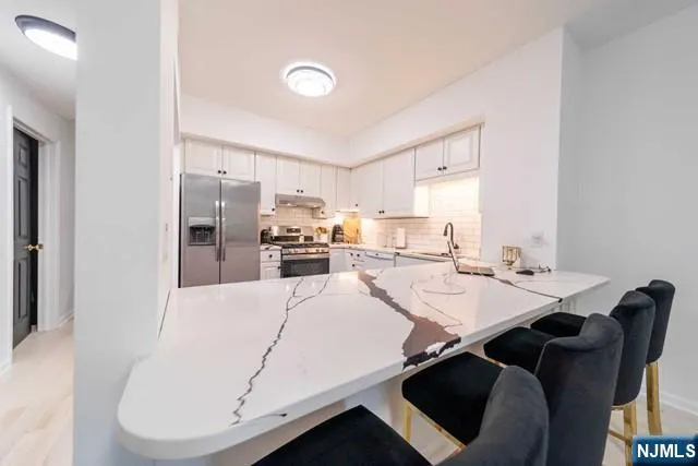 a kitchen with a table chairs a stove a microwave and cabinets