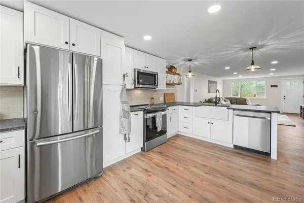 a large kitchen with a refrigerator and a stove top oven