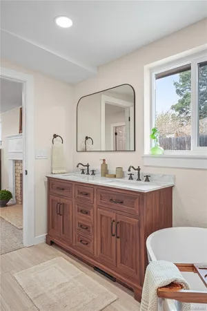 a bathroom with a granite countertop double vanity sink a mirror and a