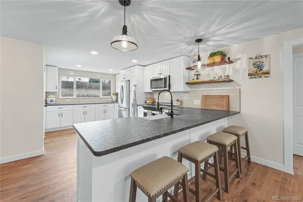 a kitchen with a table chairs and wooden floor