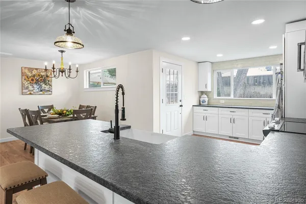 a view of a kitchen with kitchen island a sink stainless steel appliances and cabinets