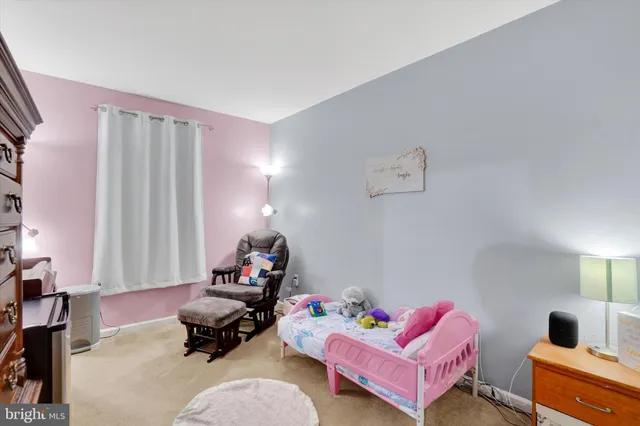 a bedroom with a bed and teddy bear on bed